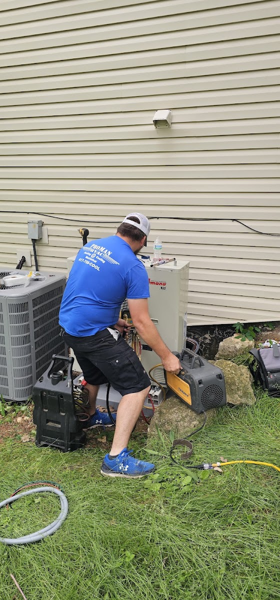 Technician working on HVAC unit outside.